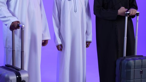الإستعداد لقضاء الإجازة الصيفية والذهاب في رحلة سفر ممتعة، تصوير لرجل عربي خليجي عماني يرتدي الدشداشة والكمة يقف مع زوجته وابنه ويمسك حقيبة الأمتعة، الأجواء العائلية المليئة بالحب