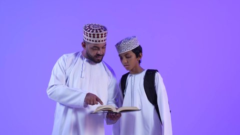 مفهوم الاجتهاد والمثابرة للوصول الى المراتب العليا،  التعلم في المدارس المتطورة في سلطنة عمان،الاستعداد لبدء عام دراسي جديد، تصوير لأب عربي خليجي عماني يقوم بمساعدة ابنه بالتجهز للذهاب الى المدرسة