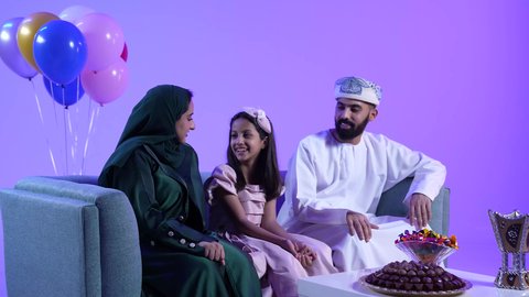 تقديم الضيافة العربية والحلويات الشعبية، الزيارات العائلية والاحتفال بالأعياد الإسلامية،تصوير لعائلة عربية خليجية عمانية تقوم بتبادل المعايدات, إظهار مشاعر الفرح والسعادة بقدوم العيد، مفهوم الحنان والمحبة والمودة