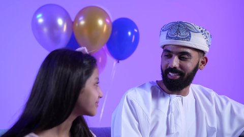 مفهوم الحب والبر بالوالدين، تجمع العائلة العمانية لاستقبال العيد المبارك, إظهار مشاعر الفرح والسعادة بقدوم العيد، تصوير لعائلة عربية خليجية عمانية تجلس في غرفة المعيشة بايماءات السعادة ، مفهوم الحنان والمحبة والمودة