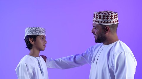 تبادل الاحاديث و الحوارات مع الابناء, تصوير لولد عربي خليجي عماني مع والده يحتفلون في العيد المبارك, ايماءات الفرح والسعاده, الزيارات و التجمعات الاسريه, الأعياد والمناسبات الاسلامية السعيدة