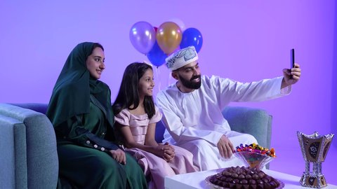 Greetings, congratulations, and rituals of Islamic occasions in the Sultanate of Oman, documenting memorable moments, wearing traditional Omani costumes, photographing an Omani Gulf Arab family celebrating Eid al-Adha, an atmosphere of joy, happiness, and decorations, and giving Eid gifts to children during Eid.