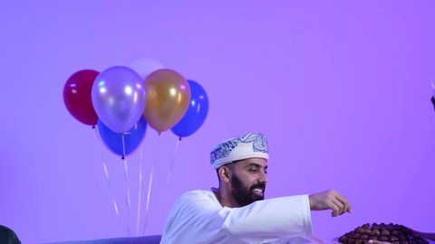 ارتداء الأزياء العمانية التقليدية،جو البهجة والفرح والزينة، توزيع الحلويات الشعبية في الأعياد، طقوس الاحتفالات والمناسبات السعيدة في سلطنة عمان، تصوير لعائلة عربية خليجية عمانية تحتفل بالعيد المبارك، مفهوم الكرم وتقديم الضيافة العربية