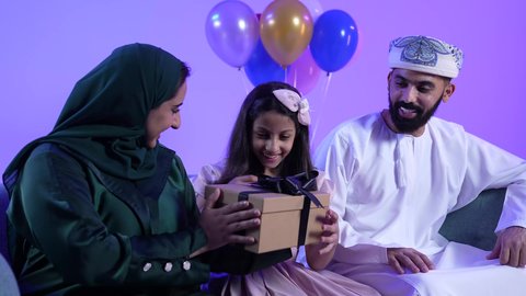 الألفة والمودة بين أفراد الأسرة العمانية، الاجتماعات والاحتفالات العائلية،  مشاركة وتقديم الهدايا بالمناسبات وأعياد الميلاد, تصوير لعائلة عربية خليجية عمانية تحتفل بالعيد المبارك ، ايماءات الرضا والسرور