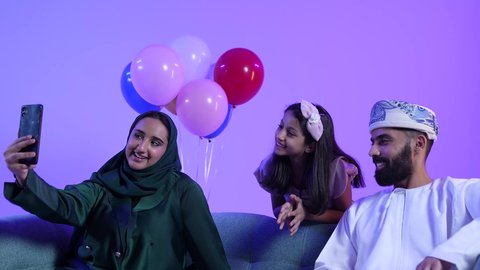 توثيق اللحظات التذكارية ، المعايدات والتهنئات وطقوس المناسبات الاسلامية في سلطنة عمان، ارتداء الأزياء العمانية التقليدية، تصوير لعائلة عربية خليجية عمانية تحتفل بالعيد المبارك، جو البهجة والفرح والزينة، تقديم العيديات للاطفال فى العيد