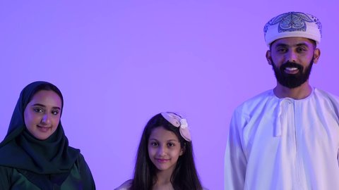 إظهار مشاعر المودة والمحبة العائلية, السلام والتهنئة بقدوم العيد, النظر الى الكاميرا بايماءات السعادة ، أجواء البهجة والسعادة والاحتفال, تصوير لعائلة عربية خليجية عمانية تحتفل بالأعياد الاسلامية