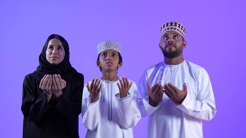 الدعاء و التضرع لله , تصوير لعائلة عربية عمانية خليجية , ترتدي الزي التقليدي العماني , يرفعان يدهم إلى الأعلى , العبادة و تقرب الى الله تعالى في شهر رمضان المبارك
