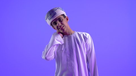 إيماءات الألم في الرقبة ، طلب المساعده للذهاب الى المستشفى، التهاب العضلات والمفاصل، الإحساس بالتعب والإرهاق, بورتريه لولد عربي خليجي عماني يرتدي الدشداشة والكمة يضع يده على رقبته بتعابير الوجع، الحاجه لوضع خطة علاجية, خلفية زرقاء .
