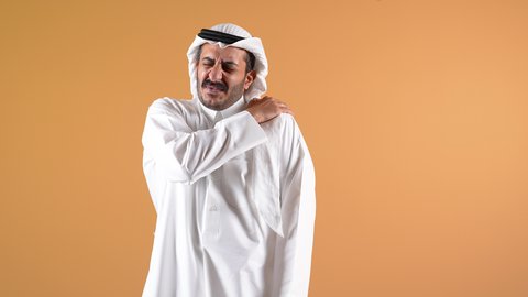 التهاب العضلات والمفاصل، الإحساس بالتعب والإرهاق, إيماءات الألم في الأكتاف، تصوير لرجل عربي خليجي قطري يرتدي الثوب و الغترة يضع يده على كتفه بتعابير الوجع، الحاجه لوضع خطة علاجية, طلب المساعده للذهاب الى المستشفى
