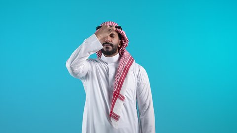 الانزعاج لسماع الأخبار السيئة،إيماءات الندم والتحسر على موضوع معين، الصمت والتوقف عن الكلام, تصوير لرجل عربي خليجي بحريني يرتدي الثوب التقليدي والشماغ يضع يده على وجهه