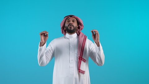 التهديد و التوعد لشيء ما بتعابير الغضب،مفهوم الصبر والتريث و التأني,  تصوير لرجل عربي خليجي بحريني يرتدي الثوب التقليدي والشماغ ينظر الى الكاميرا يرفع يده نحو الأعلى بإيماءات طلب الإنتظار, إمهال بعض الوقت لفعل شيء
