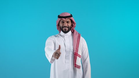 تعابير القبول والفرح والسرور، الاهتمام بالأناقة والمظهر الخارجي، تصوير لرجل عربي خليجي بحريني يرتدي الثوب التقليدي والشماغ ينظر الى الكاميرا ويرفع إصبع السبابة للاعلى بإيماءات الإعجاب والرضا