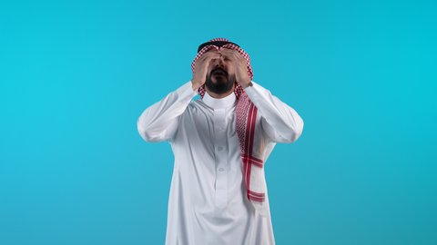 تعابير الخجل والحياء، تذكر شيء ما بشكل مفاجئ، تصوير لرجل عربي خليجي بحريني يرتدي الثوب التقليدي والشماغ يغطي عينيه بيده بايماءات السعادة، الشعور بالفرح والسرور