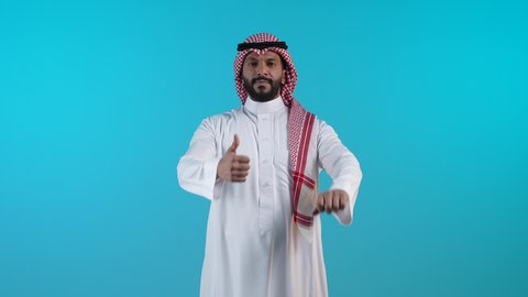 الاهتمام بالأناقة والمظهر الخارجي، تعابير القبول والفرح والسرور، تصوير لرجل عربي خليجي بحريني يرتدي الثوب التقليدي والشماغ ينظر الى الكاميرا ويرفع إصبع السبابة للاعلى بإيماءات الإعجاب والرضا