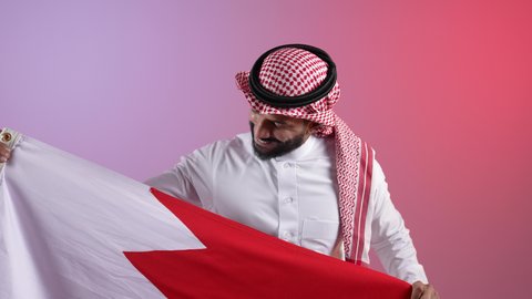 رموز وثقافات وطنية, حب الوطن والانتماء إليه، الاحتفال باليوم الوطني القطري 18 ديسمبر، إحياء ذكرى تأسيس الدولة، تصوير لرجل عربي خليجي قطري يحمل علم قطر بايماءات الفخروالاعتزاز، خلفية ملونه