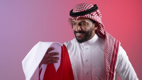 Commemorating the founding of the state, celebrating Qatar National Day, December 18, a picture of a Qatari Gulf Arab man holding the Qatari flag with gestures of pride and honor, national symbols and cultures, love of the homeland and belonging to it, a colorful background