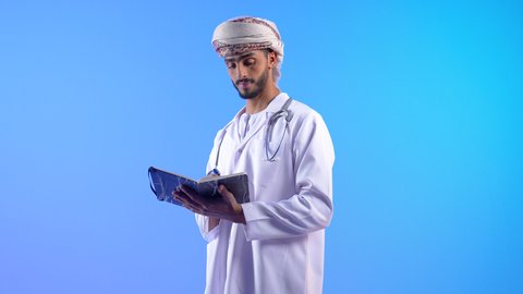 الوقوف باستقامة وتقديم الخدمات الصحية والطبية، تدوين المعلومات العامة عن حالة المريض، ممرض عربي خليجي عماني يرتدي الدشادشة و العمامة يضع السماعة الطبية، العمل في القطاع الطبي في سلطنة عمان، مفهوم الطب والرعاية الصحية
