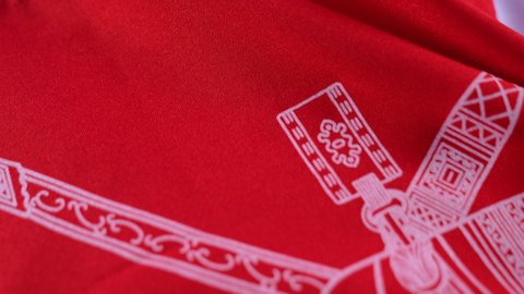 The concept of patriotism, celebrating the National Day, pride in belonging to the country, pride in the symbols and the Omani flag, a close-up portrait of an Arab Gulf Omani man wearing a dishdasha and a kurta, placing the flag of the Sultanate of Oman on his back and looking at the camera with gestures of pleasure and happiness, blue background