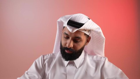 الاستمتاع بقراءة الكتب والقصص والروايات، تنمية المهارات وتوسيع المعارف والأفكار، بورتريه لرجل عربي خليجي قطري يرتدي الثوب التقليدي والغترة يجلس خلف طاولة المكتب ويمسك بيديه كتاب، زيادة الذخيرة الفكرية، قضاء أوقات الفراغ بشكل مفيد، خلفية ملونة