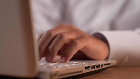 الكتابة باستخدام لوحة المفاتيح، دمج الأعمال مع التقنية والتكنولوجيا الحديثة والمتطورة، شاب سعودي يقوم بإنجاز العمل عبر اللابتوب، بورتريه مقرب لايدي رجل عربي خليجي قطري يرتدي الثوب التقليدي يقوم باستخدام الحاسوب المحمول، خلفية ملونة