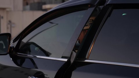 تعابير السعادة والسرور, الاستعداد لركوب السيارة، مفهوم القيادة الآمنة, رجل عربي خليجي عماني يرتدي الدشداشة و العمامة يفتح باب السيارة الامامي، خدمة النقل و التوصيل في سلطنة عمان