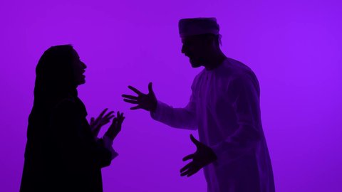 Family problems and disputes, marital crisis, concept of family conflict, silhouette of an Arab Gulf Omani man wearing a dishdasha and turban arguing with his wife due to misunderstanding, quarrel between spouses, purple background, silhouette