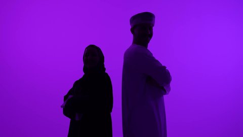 الشجار بين الزوجين، مفهوم الصراع الاسري، ازمة في العلاقات الزوجية، تصوير ظلي لرجل عربي خليجي عماني يرتدي الدشداشة والعمامة يتجادل مع زوجته بسبب سوء التفاهم، مشاكل عائلية وخلافات، خلفية بنفسجية، سالوييت