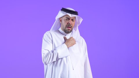 الشعور في زيادة معدل ضربات القلب، ضرورة إجراء الفحوصات اللازمة، اضطرابات و أمراض قلبية، رجل عربي خليجي كويتي يرتدي الثوب التقليدي والغترة يضع يده على صدره يشعر بحالة من الوخز والألم بقلبه ، رجل سعودي يحتاج لزيارة الطبيب