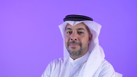 مفهوم الوسامة والرجولة والقوة، رجل عربي خليجي كويتي يرتدي الثوب التقليدي والغترة يقف باستقامة وايدي متقاطعة، رجل سعودي مهتم بالأناقة والمظهر الخارجي