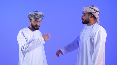 الخسارة والفشل والندم على شيء ما، بورتريه لرجل عربي خليجي عماني يرتدي الدشداشة و العمامه يرتدي يضع يديه على عينيه، الشعور بالحزن والإحباط والرغبة بالبكاء,مفهوم القهر والخسارة, خلفية زرقاء