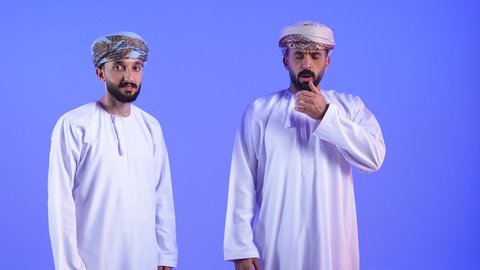 الكحة والتهاب الحلق والحاجة للعلاج، بورتريه لرجلان عربيان خليجيان عمانيان يرتدي الدشداسة و العمامة د ينظران إلى الكاميرا يضعان يدهما أمام فمهما ويقومان بالسعال, الإصابة بالأنفلونزا ونزلات البرد، خلفية زرقاء
