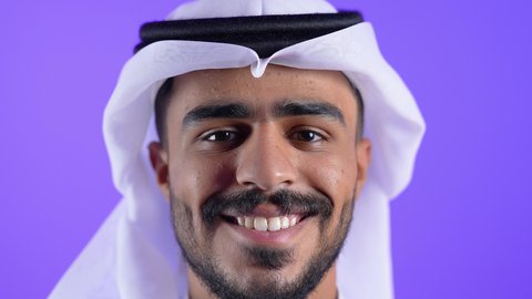 مفهوم الرجولة والثقة بالنفس، الاهتمام بالمظهر الخارجي والأناقة، شاب عربي خليجي كويتي يرتدي الثوب التقليدي والغترة يقف باستقامة وثقة بالنفس ، رجل سعودي ينظر الى الكاميرا بايماءات السرور والسعادة