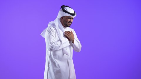 الشعور في زيادة معدل ضربات القلب، ضرورة إجراء الفحوصات اللازمة، اضطرابات و أمراض قلبية، رجل عربي خليجي كويتي يرتدي الثوب التقليدي والغترة يضع يده على صدره يشعر بحالة من الوخز والألم بقلبه ، رجل سعودي يحتاج لزيارة الطبيب