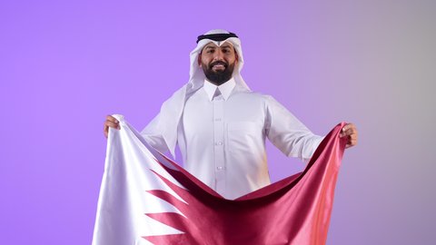 Commemorating the founding of the state, celebrating Qatar National Day, December 18, portrait of a Qatari Gulf Arab man holding the Qatari flag with gestures of pride and honor, national symbols and cultures, love of the homeland and belonging to it, purple background