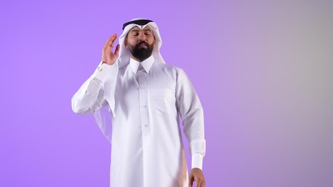 الانصات وحسن الاستماع، بورتريه لرجل عربي خليجي قطري يرتدي الثوب التقليدي والغترة يضع يده خلف أذنه بإيماءات التنصت والتجسس،شاب سعودي يقوم  بالتركيز على الكلام وسماع الاسرار، خلفية بنفسجية