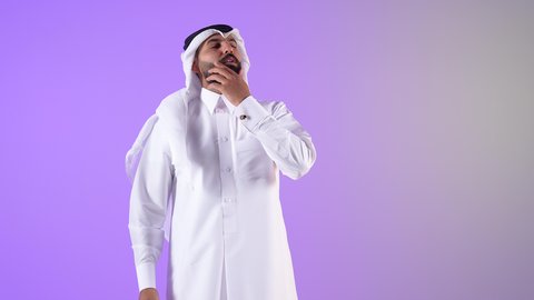 التفكير بعمق وشرود الذهن، شاب سعودي يحاول إيجاد حل للمشكلات الصعبة، القلق والحيرة في اتخاذ القرار الصحيح، بورتريه لرجل عربي خليجي قطري يرتدي الثوب التقليدي والغتره يضع يده أسفل ذقنه وينظر إلى مكان ما بعيد بإيماءات الاندماج، خلفية بنفسجية