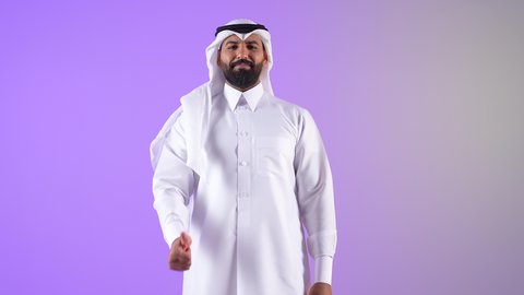 علامة الجودة والامتياز, بورتريه لرجل عربي خليجي قطري مبتسم يرتدي الثوب التقليدي والغترة يرفع ابهامه بإيماءات الموافقة والقبول, شاب سعودي يشعر بالاعجاب والرضا لتحقيق أمر معين، خلفية بنفسجية