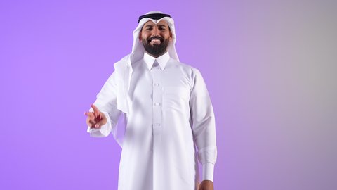 إشارة الفوز والانتصار،شاب سعودي  يرفع علامة النصر والسلام، تحقيق الأهداف والطموحات، إنجاز المهام المحددة، إشارات وحركات لغة الجسد، بورتريه لرجل عربي خليجي قطري مبتسم يرتدي الثوب التقليدي والغتره ينظر للكاميرا بإيماءات السعادة والسرور، خلفية بنفسجية
