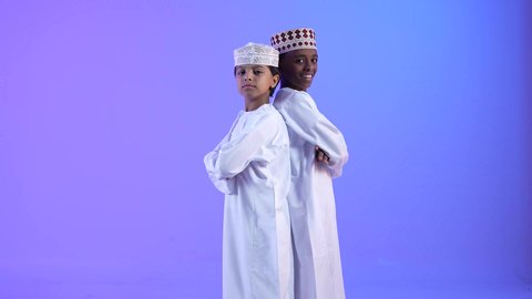 الاهتمام بالأناقة والمظهر الخارجي، مشاعر الحب بين الاخوة,  صديقان عربيان خليجيان عمانيان يرتديان الدشداشة والكمة ، ينظران الى الكاميرا بإيماءات السرور، التقاط الصور الشخصية