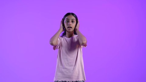 النظر إلى الكاميرا بتعابير الدهشة والخوف،الصدمة والتعجب من حصول أمر ما،  بنت عربية خليجية عمانية تضع يديها على وجهها بإيماءات تدل على الذهول