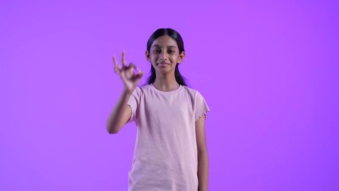 مفهوم القبول والموافقه ، تعابير الإعجاب والرضى، بنت عربيه خليجيه عمانية مبتسمة ترتدي الزي الكاجوال ترفع اصبع الابهام بإيماءات الامتياز والجودة