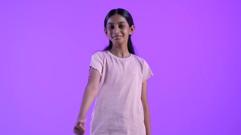 Expressions of admiration and satisfaction: A smiling Omani Gulf Arab girl in casual wear raises her thumb in a gesture of excellence and quality. The concept of acceptance and approval.