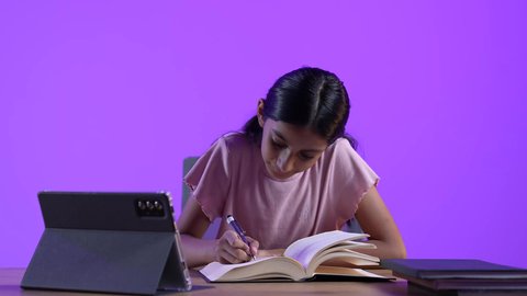 تطور العلم والتعليم في سلطنه عمان، مراجعة الدروس اليومية عبر الانترنت، مفهوم التعلم عن بعد ،  طالبة عربية خليجية عمانية ترتدي الزي الكاجوال تجلس على طاولة امام جهاز التابلت المحمول تقوم بحل الواجبات المدرسيه ،  تلقي المحاضرات المدرسيه عن بعد