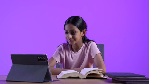 دمج التقنيات الحديثة فى الحياة اليومية ، تلقي المحاضرات المدرسيه عن بعد، تطور العلم والتعليم في سلطنه عمان،مراجعة الدروس اليومية عبر الانترنت، طالبة عربية خليجية عمانية ترتدي الزي الكاجوال تجلس على طاولة امام جهاز التابلت المحمول تقوم بحل الواجبات المدرسيه