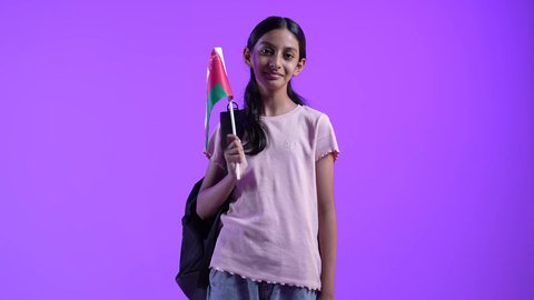 مفهوم حب الوطن والإنتماء إليه، إحياء ذكرى اليوم الوطني العماني، بنت عربية خليجية عمانية ترتدي الزى الكاجوال ،تمسك علم لسلطنة عمان بايماءات الفرح والسرور، الاعتزاز والفخر بالرموز العمانية