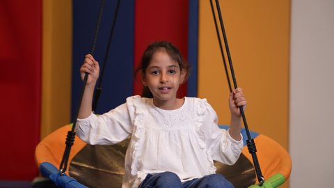 قضاء اوقات رائعة في مدينة الملاهي ، بنت سعودية مبتسمة ترتدي الزى الكاجوال في مدينة الألعاب ، تلعب لعبة المراجيح المسلية، الاستمتاع باللعب في العطلة الصيفية ، اوقات التسلية و الترفيه