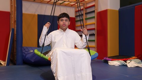 قضاء اوقات رائعة في مدينة الملاهي ،، ولد سعودي مصاب بمتلازمة داون في مدينة الألعاب ، يلعب لعبة المراجيح المسلية، الاستمتاع باللعب في العطلة الصيفية ، اوقات التسلية و الترفيه