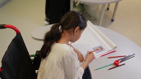 تنمية المهارات الفنية في الروضات السعودية ، مفهوم الاهتمام بالهوايات,إيماءات التركيز والاستمتاع بالرسم و التلوين، بنت عربية خليجية سعودية ترتدي الزي الكاجوال تقوم بالرسم والتلوين بالألوان ، قضاء اوقات ممتعه