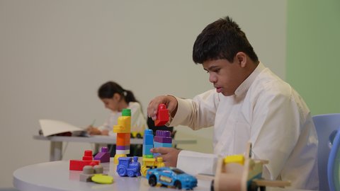 تعزيز المهارات الذهنية والفكرية،مراكز الالعاب الترفيهيه في السعودية ،  قضاء أوقات ممتعة باللعب والتركيز، ولد سعودي مصاب بمتلازمة داون، يقوم بتركيب المكعبات ، رعاية وتطوير مهارات الأطفال