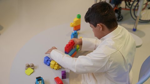 مراكز الالعاب الترفيهيه في السعودية ،  قضاء أوقات ممتعة باللعب والتركيز، تعزيز المهارات الذهنية والفكرية، ولد سعودي مصاب بمتلازمة داون، يقوم بتركيب المكعبات ، رعاية وتطوير مهارات الأطفال